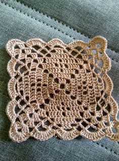 a crocheted doily is laying on top of some blue jeans with holes in it