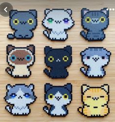 cross stitch cats are shown on a wooden surface