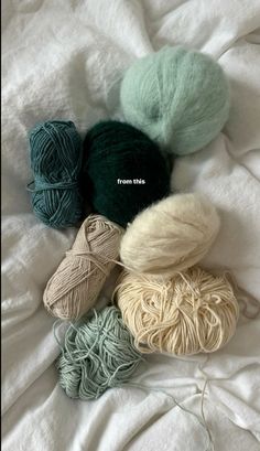 several skeins of yarn laid out on a bed