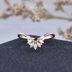 a diamond ring sitting on top of a black surface next to a branch with white flowers