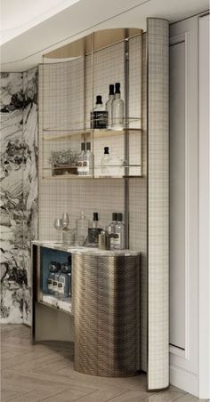 a bathroom with marble walls and flooring next to a shelf that has bottles on it