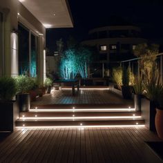 an outdoor deck lit up with lights and potted plants