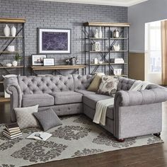 a living room with a sectional couch and bookshelves on the wall behind it