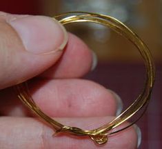 a close up of a person holding a gold ring