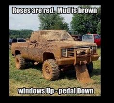 a truck that is sitting in the grass with mud all over it's tires