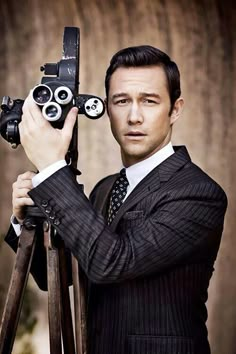 a man wearing a suit and tie holding a pair of binoculars