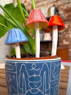 three little mushrooms sitting on top of a potted plant