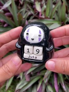 a person holding a small black and white figurine with the number 19 on it