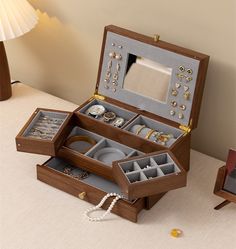 an open jewelry box sitting on top of a table next to a lamp and mirror