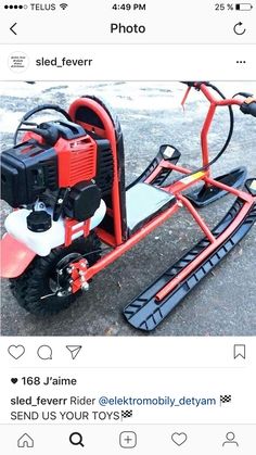 a red and black snowmobile sitting on top of cement