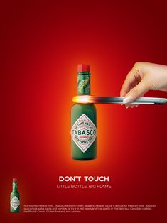 an advertisement for tabasco with a bottle being held by a person's hand