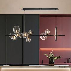 an image of a kitchen with lights hanging from it's ceiling and cabinets in the background