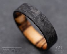 a wooden ring with black and brown wood inlay