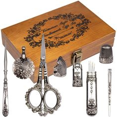 an assortment of silverware in a wooden box with scissors and other items around it