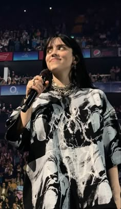 a woman holding a microphone in front of a crowd