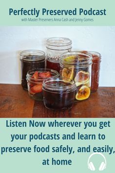 jars filled with fruit sitting on top of a wooden table