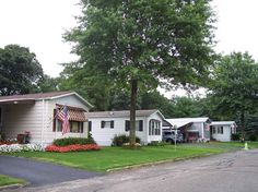 a couple of houses sitting next to each other on top of a lush green field