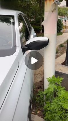 a white car parked next to a tall pole