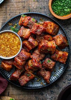 a plate full of meat with sauce on it next to other food items and garnishes