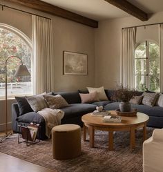 a living room filled with furniture and lots of window sill space next to a couch