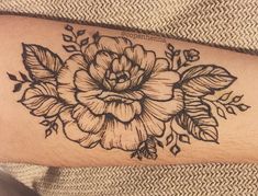 a black and white flower tattoo on the arm