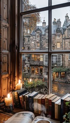 an open book sitting on top of a window sill next to a bunch of books