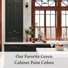 a kitchen with black cabinets and white counter tops, green cabinet paint colors on the walls