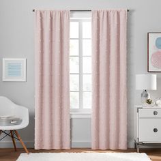 a pink curtain with polka dots on it in front of a white chair and window