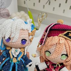 two crocheted dolls sitting next to each other