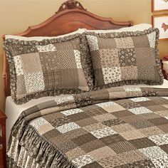 a bed with a brown and white checkered comforter set on top of it