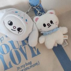 two white teddy bears are on a blue and white keychain that says, happy you're loved in my bag everyone