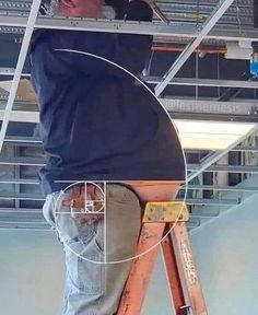 a man standing on a ladder working on the ceiling