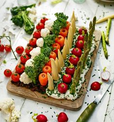 a wooden cutting board topped with lots of vegetables