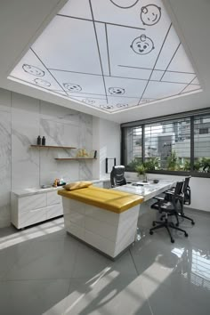 an office with white walls and yellow counter top in front of a large open window