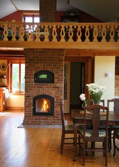 a living room with a fire place in the fireplace and wooden furniture on the floor