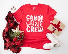 Candy Cane Crew Shirt, Christmas T-shirt, Christmas Shirt, Christmas Season Tee, Christmas Gift, Candy Cane Shirt, Matching Christmas Shirt ❗❗ Price is for per item. This item is just for a shirt, not a set. Shirts are sold separately. Please, add as many as you need to your cart. Hello!! We wish everyone to smile with our cute, stylish, and trendy graphic shirts. We assure you these shirts are the perfect gifts whether you buy them for yourself or someone else. IMPORTANT! Black design is only used for Orange, Heather Peach, Athletic Heather, Mint, and White colored shirts. White design is used for other colors. Please, check the size chart before you purchase. HOW TO MAKE AN ORDER *Pick your shirt type and size Your design will be printed on the front. *Pick your shirt color PRODUCTION Pr Candy Cane Shirts For Kids, Red Letter Print Shirt For Gift, Red Crew Neck Holiday Shirt, Red Crew Neck Shirt For Holiday, Candy Cane Day At School Outfits, Candy Cane Outfit Women, Candy Cane Shirt Ideas, Candy Cane Shirt, Toddler Christmas Shirt