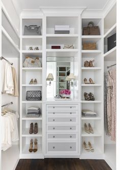 an organized closet with white shelves and drawers