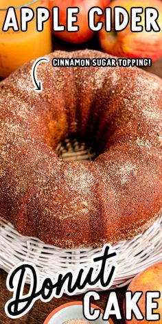 an apple cider cinnamon sugar toping donut cake on a table with apples in the background