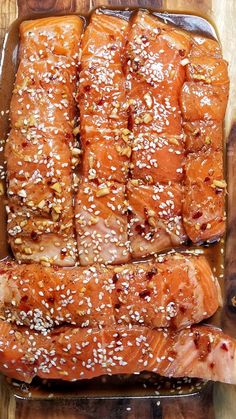 salmon wrapped in sesame seeds on a wooden cutting board