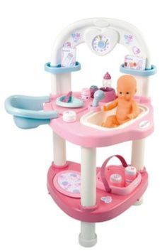 a baby doll in a pink and blue bathtub with toys on it's shelf