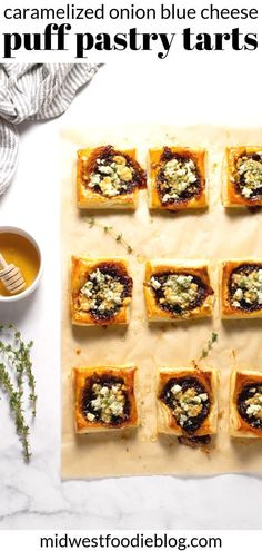 homemade puff pastry tarts with blue cheese and herbs on parchment paper next to cup of tea