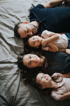 three people are laying on a bed together