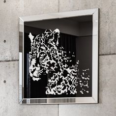 a black and white image of a tiger in a mirror on the wall above it