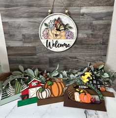 the welcome sign is hanging on the wall next to some fake pumpkins and other decorations