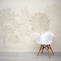 a white chair sitting in front of a wall with trees on it