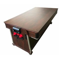 a large wooden table with two red knobs on the front and one black button on the back