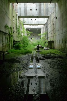 a man is walking through an abandoned building with puddles in the floor and walls