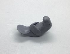 a small gray seal toy sitting on top of a white surface