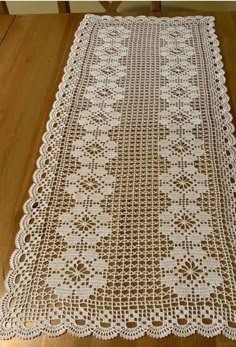 a crocheted table runner on a wooden floor