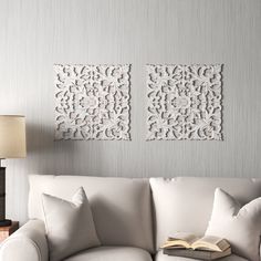 a living room with two white couches and a book on the table in front of it